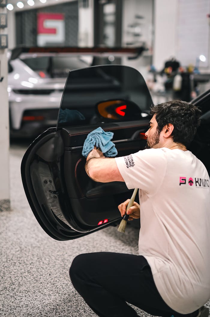 A man cleaning the window of a car